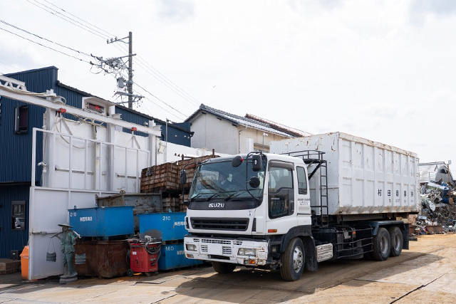 金属リサイクル現場で鉄・銅を運搬するトラックと荷下ろし場の風景